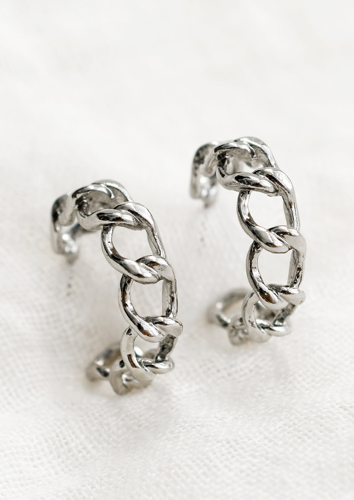 A pair of chainlink hoop earrings in silver.