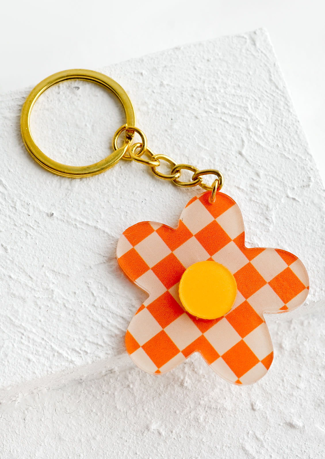 Flower shaped keychain in orange checker print.
